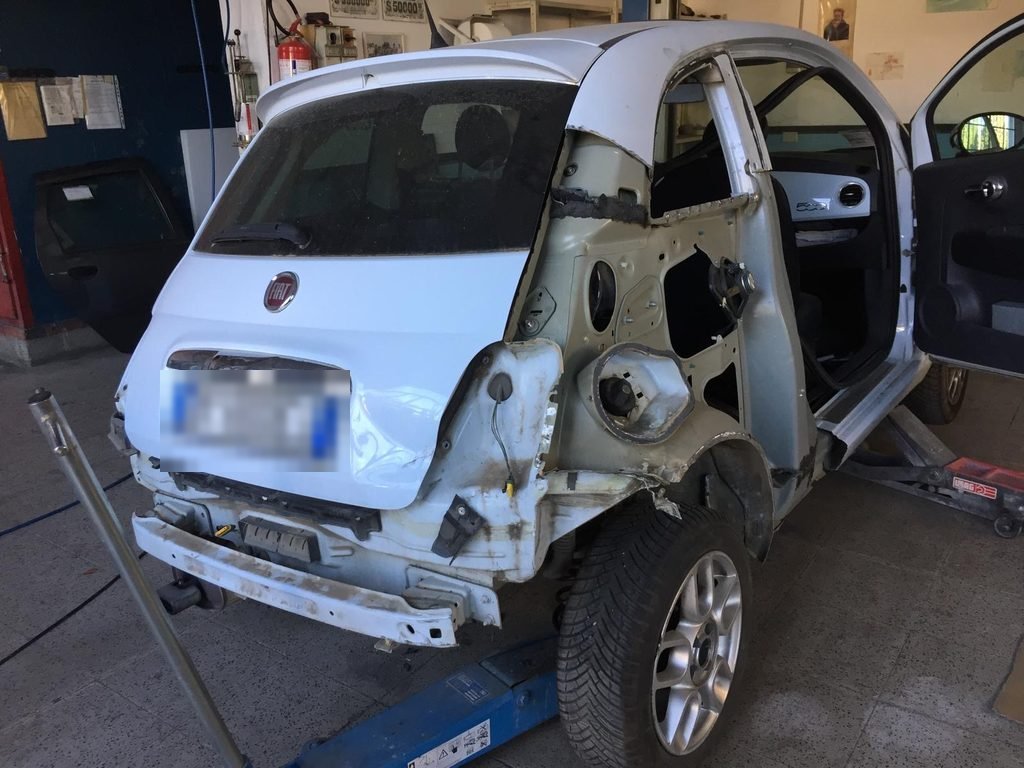 Fiat 500 in riparazione con la fiancata posteriore smontata